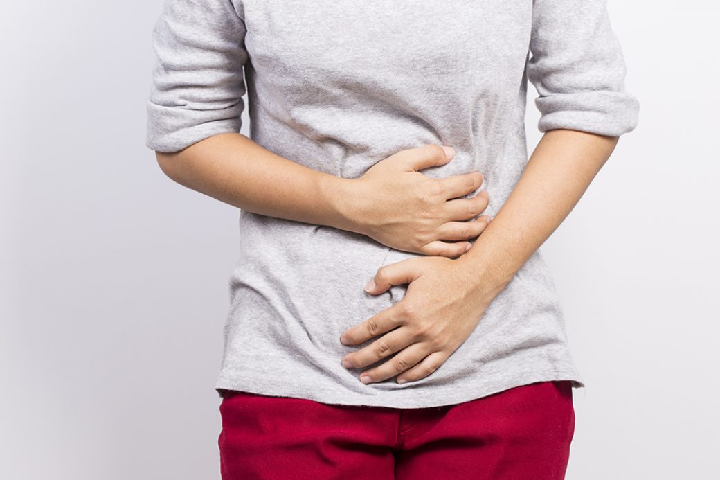 photo of woman holding stomach