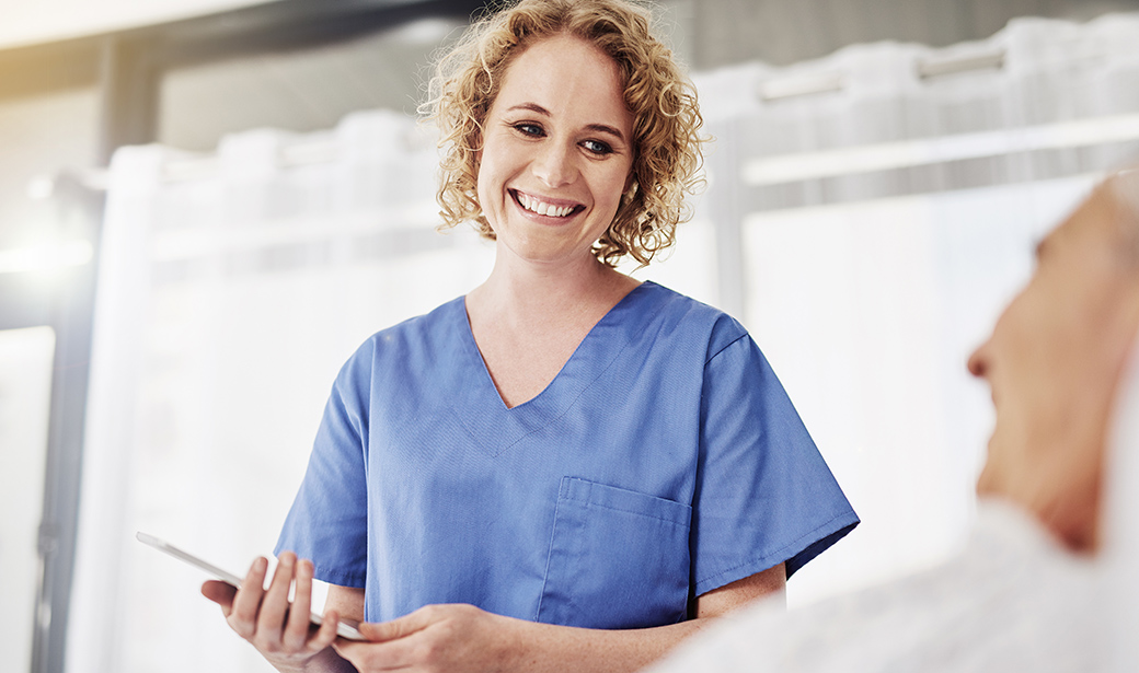 smilng female doctor holding a tablet with patient 