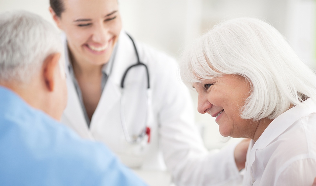 doctor smiling and helping elderly patient