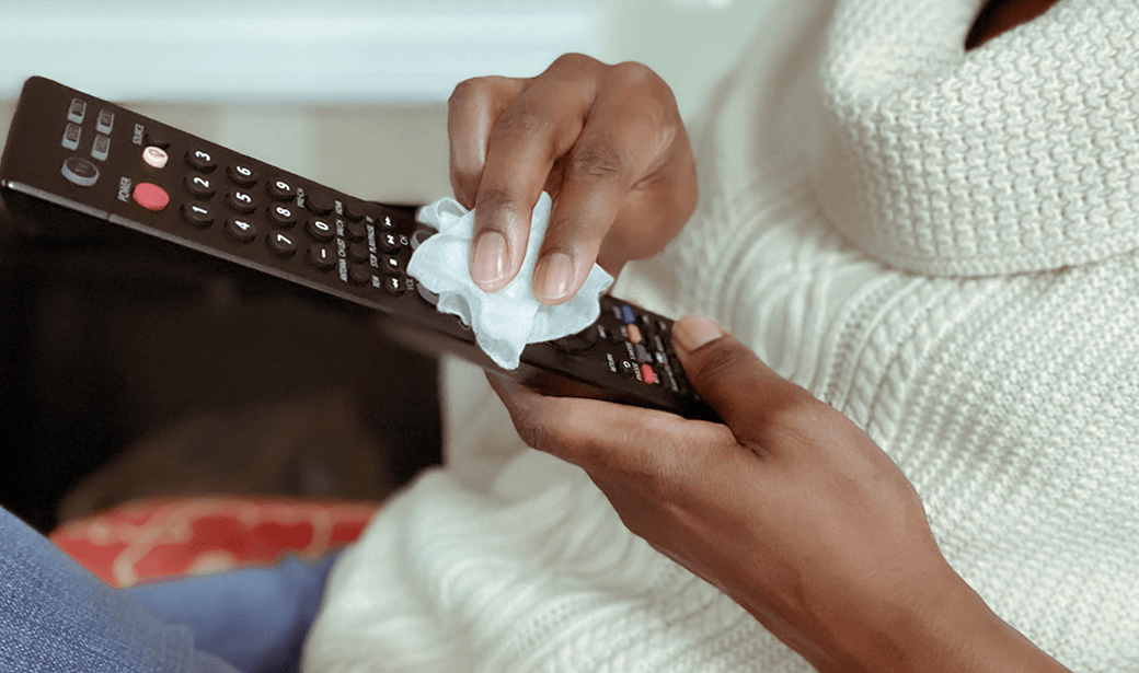 Woman wiping remote control