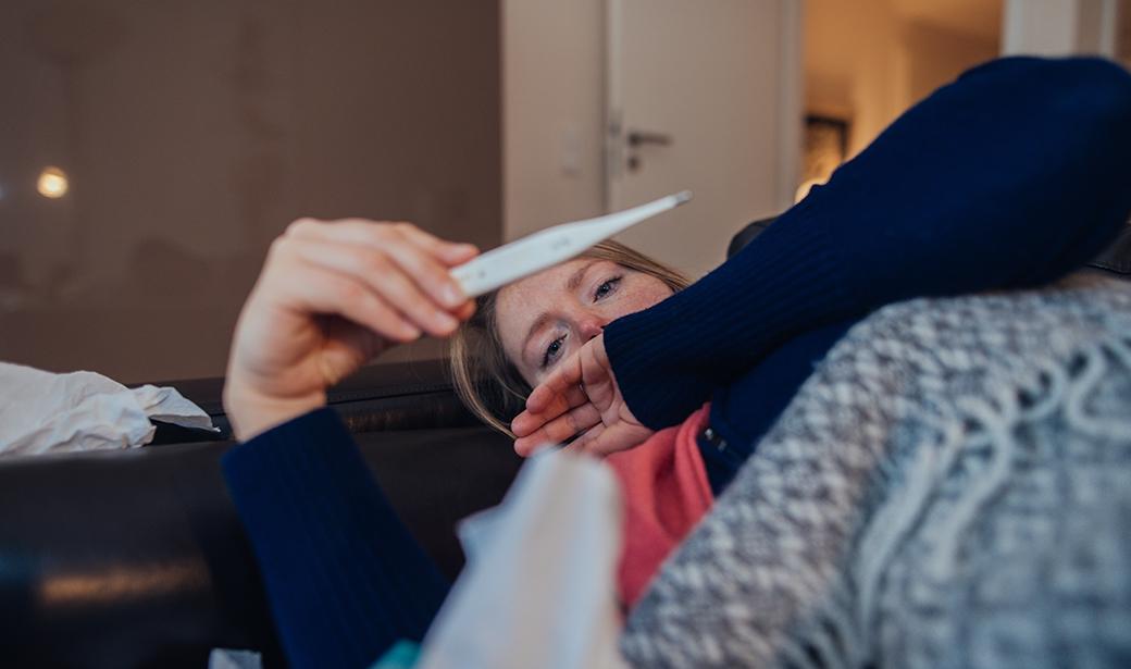 Sick woman taking her temperature