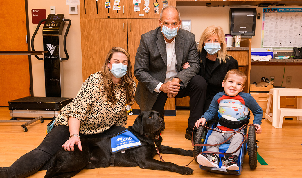 Gary Pinkel and his wife, Missy, with Blaze a Children’s Therapy Center facility dog and Brody Moreland, a therapy patient.