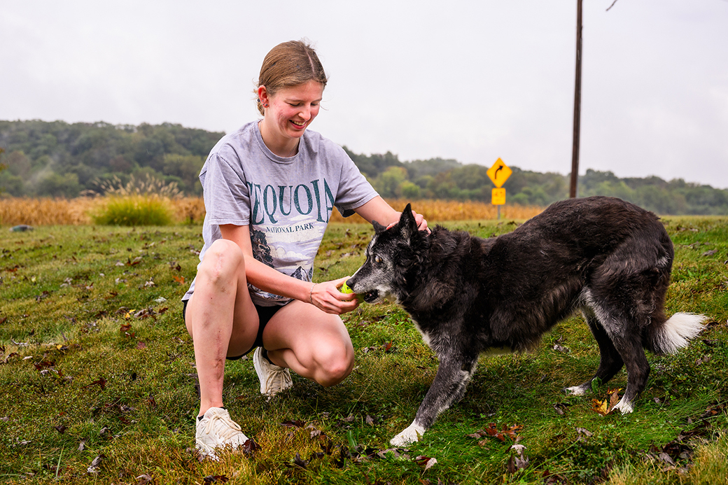 A girl playing with her dog outdoors.