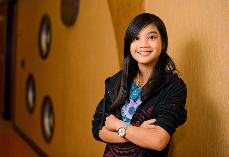 adolescent girl standing with arms crossed