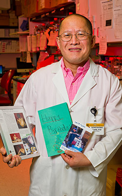 Photo of Dongsheng Duan holding handmade cards.