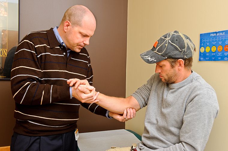 photo of doctor and patient with shoulder and elbow pain