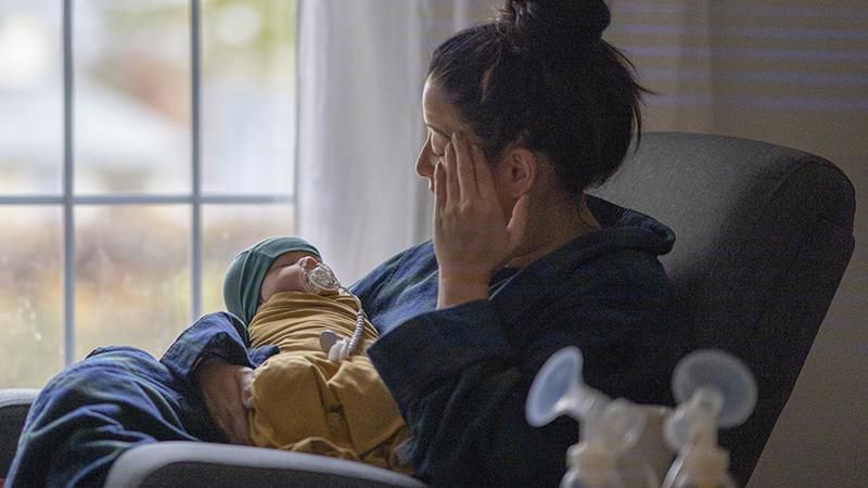 tired mom holding baby