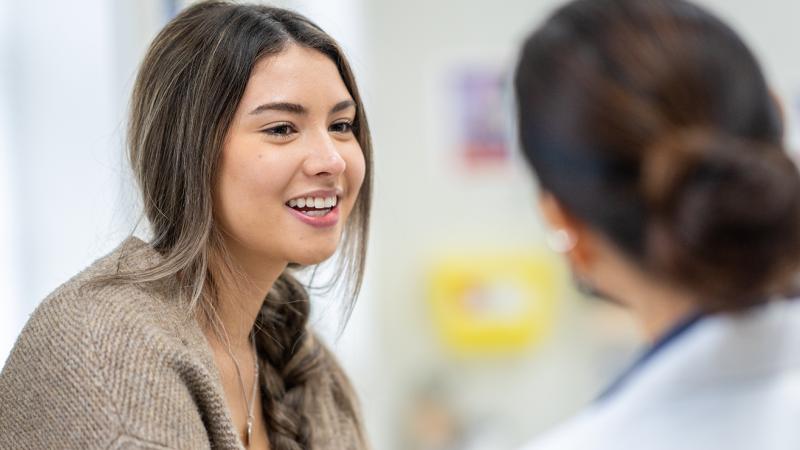 A woman talking to a primary care physician.