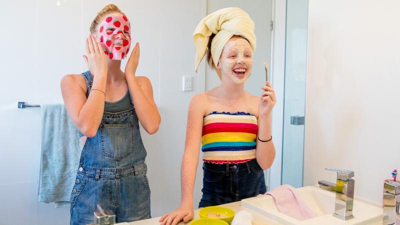 Two teens putting on skincare product