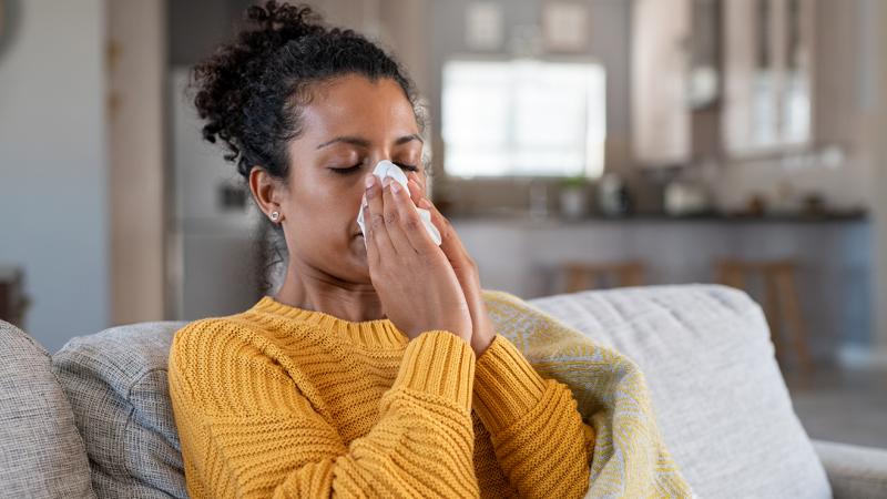 A woman blowing her nose.