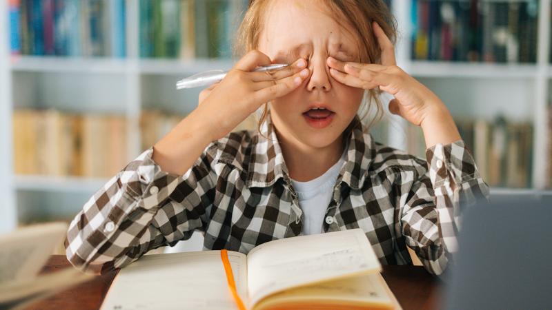 A little girl rubbing her eyes.