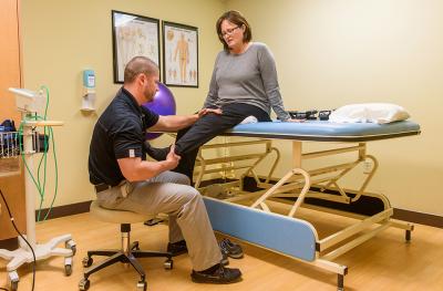 Female patient stretching knee on table