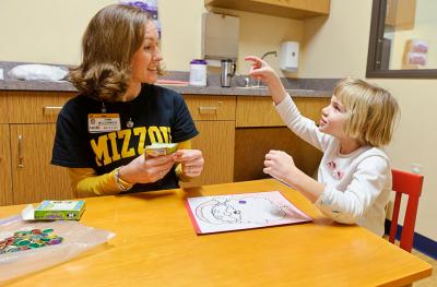 young girl in talking to speech therapy