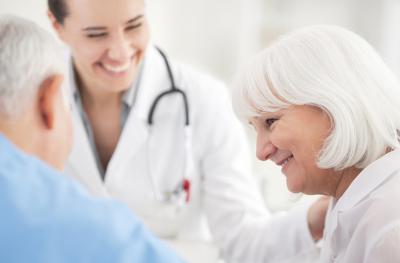 doctor smiling and helping elderly patient
