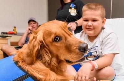 Link, the facility dog for Children’s Hospital, visits 9-year-old Kale West