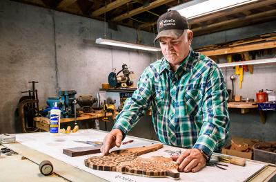 Rick Allain builds a jaguar from pieces of wood in his basement workshop