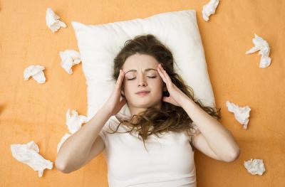 woman with cold surrounded by tissues
