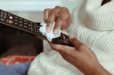 Woman wiping remote control
