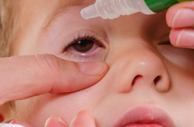 child getting eye drops