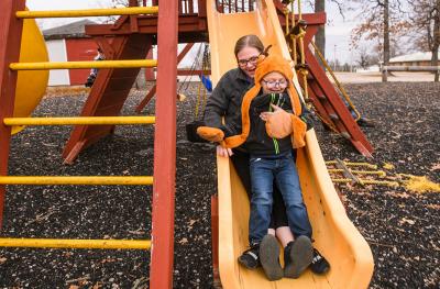 Carol Sparks-McCord goes down a slide with her son Nicholas at a park near their home in Dixon, Missouri. 
