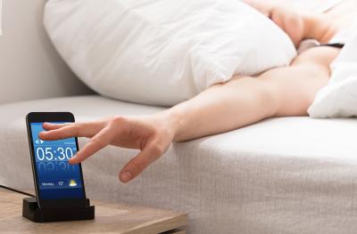 person turing off an alarm clock