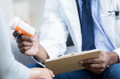doctor handing pill bottle to patient