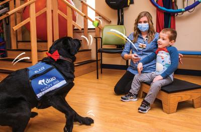 Blaze, a Children’s Therapy Center’s facility dog with a patient
