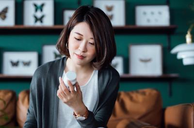 woman looking at pill bottle