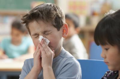 young boy blowing his nose