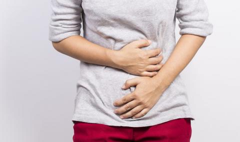 photo of woman holding stomach