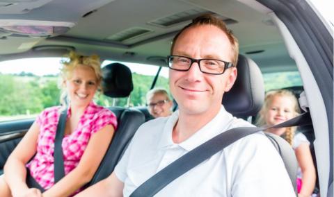 Family driving in car with seat belt fastened.