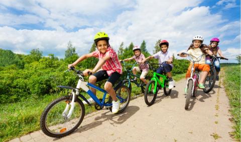 Happy kids riding bikes like in race together.