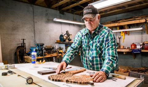 Rick Allain builds a jaguar from pieces of wood in his basement workshop