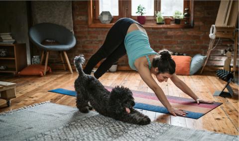 Woman working out at home with dog