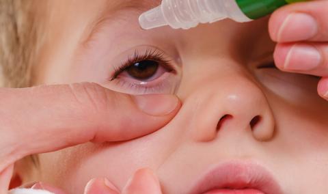 child getting eye drops