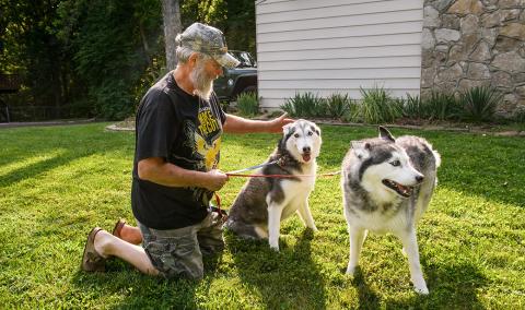 Kevin Bowers plays with his dogs