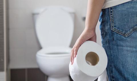 person at toilet with toilet paper