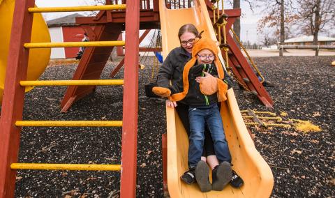 Carol Sparks-McCord goes down a slide with her son Nicholas at a park near their home in Dixon, Missouri. 
