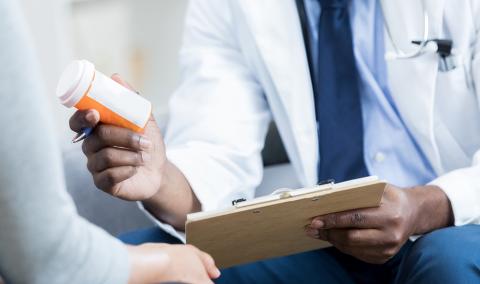 doctor handing pill bottle to patient