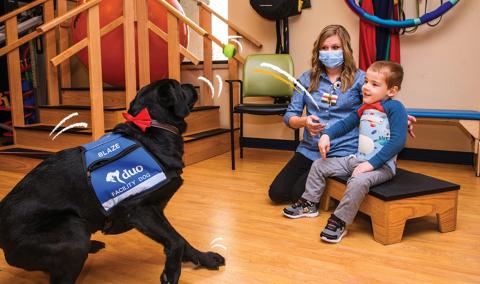 Blaze, a Children’s Therapy Center’s facility dog with a patient