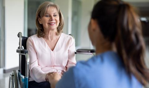 woman in a wheelchair talking to a doctor