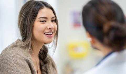 A woman talking to a primary care physician.