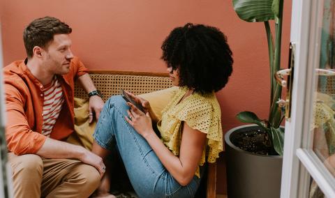 A man and a woman sitting on a sofa.