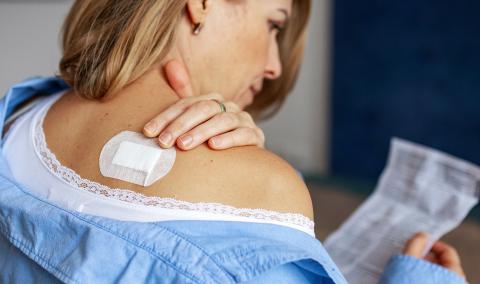 A photo of a woman reading over a prescription.