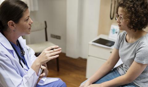 A physician speaking with a woman.