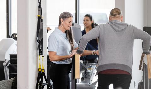 People exercising on some fitness equipment.