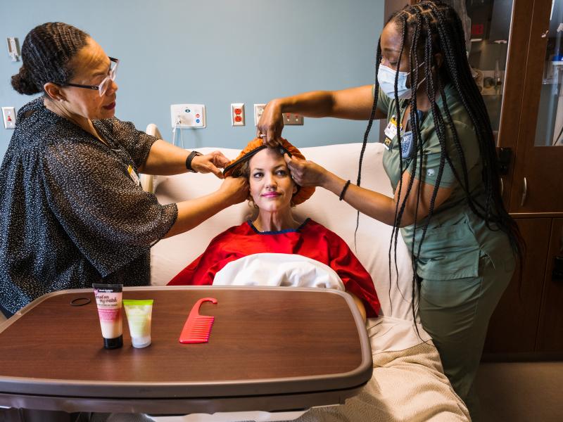Sonya Willis (left) teaches an MU Health Care technician how to treat a patient's curly hair.