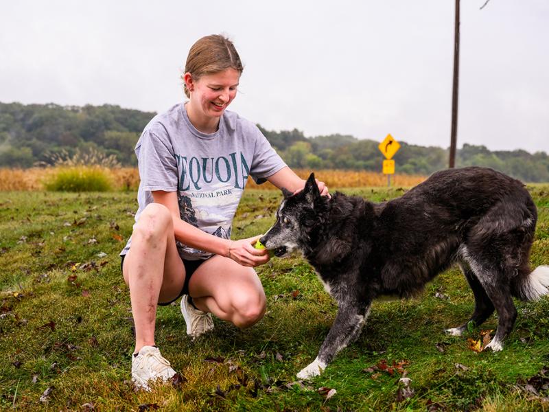 A girl playing with her dog outdoors.