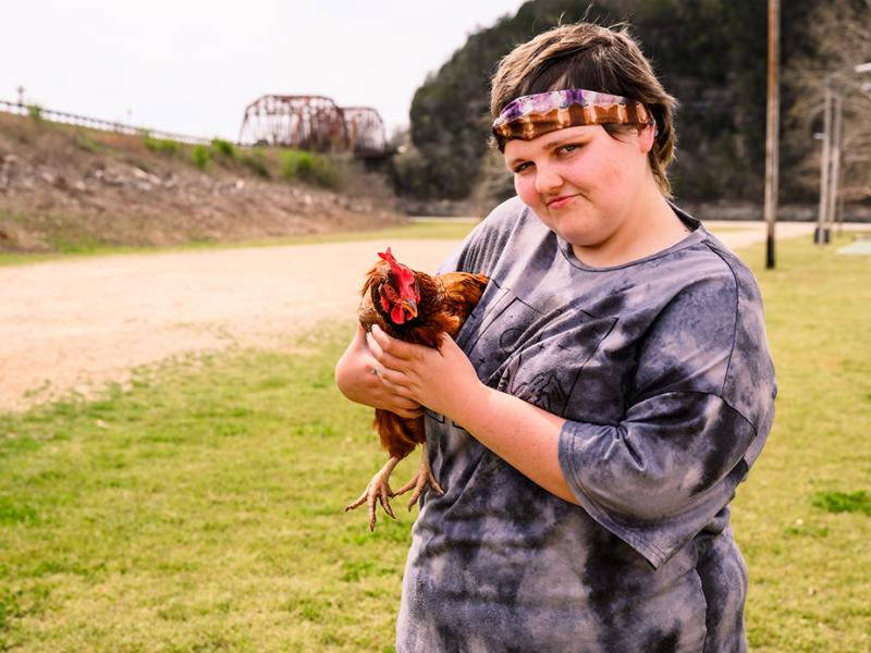 A photo of Caitlynn holding a chicken.