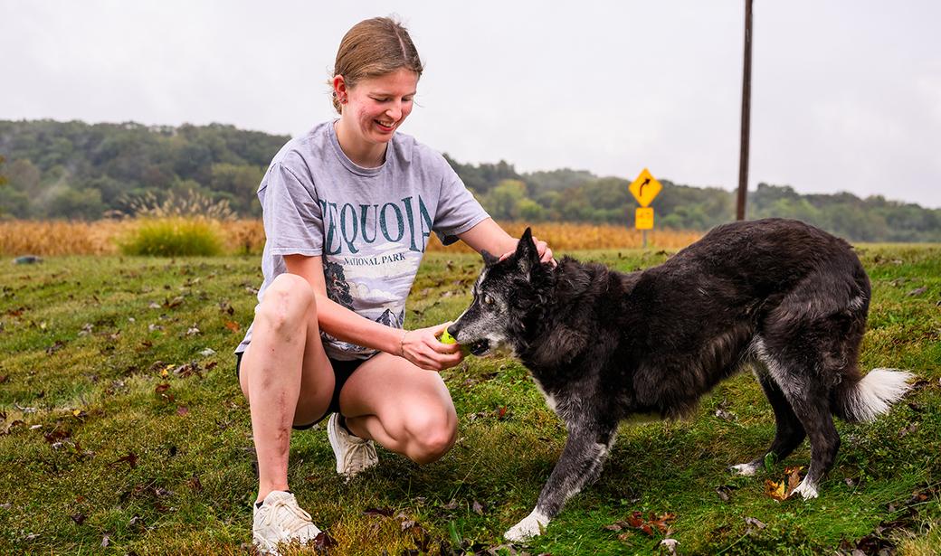 A girl playing with her dog outdoors.